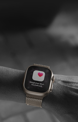 Eine Person trgt die Apple Watch Ultra 3 am Handgelenk, Hinweis zur Gesundheit auf dem Display: Mglicher Bluthochdruck