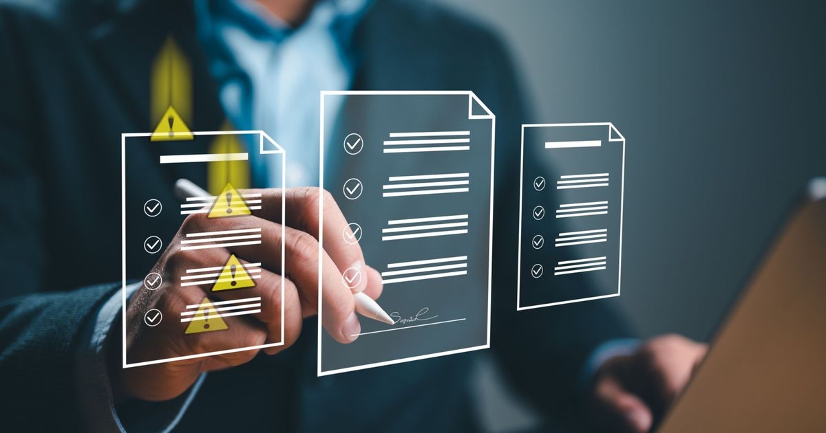 Mann unterschreibt auf einem mehrseitigen Webformular. Auf einer Seite des Webformulars fallen zeitgleich von oben Warnsymbole auf die Textzeilen.