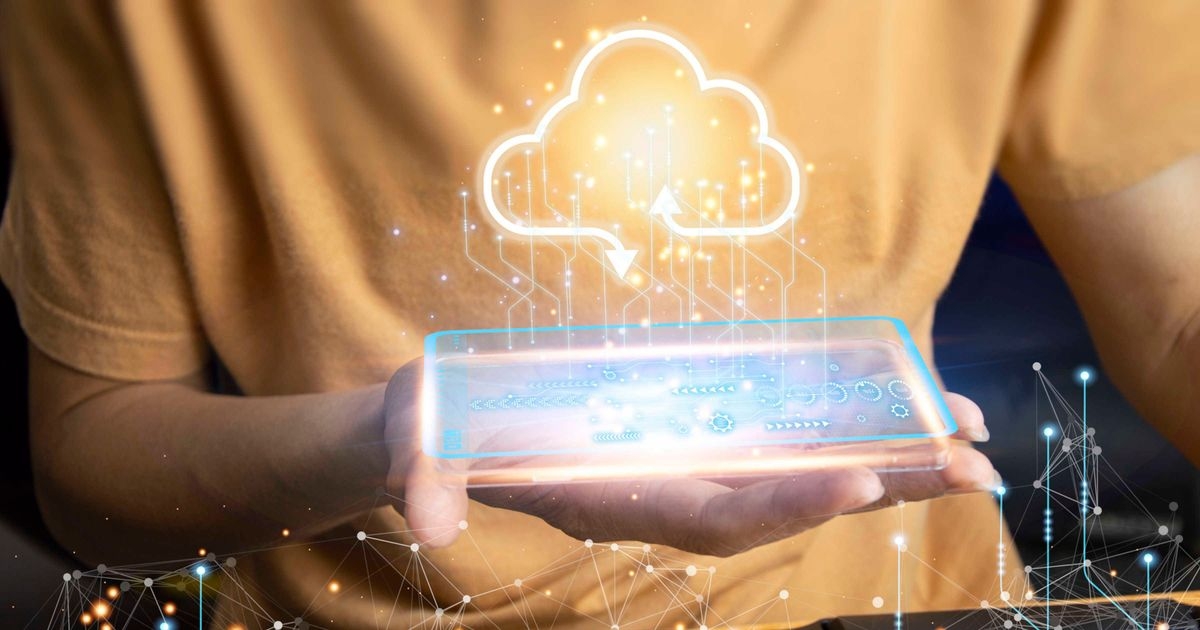 Vor dem Oberkörper einer Person ist zentral ein Wolkensymbol mit einem Pfeil nach innen und nach außen platziert. Darunter hält die Person eine Schale über einer Tastatur. Im Vordergrund finden sich digitale Leiterbahnen.