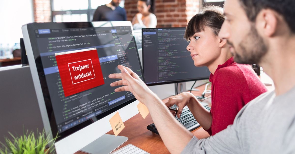 Trojaner sollten Sie rechtzeitig erkennen, bevor diese Schaden anrichten Ein Mann und eine Frau sitzen vor einem Computerbildschirm mit Programmcode. Auf dem Bildschirm der Warnhinweis „Trojaner entdeckt“.