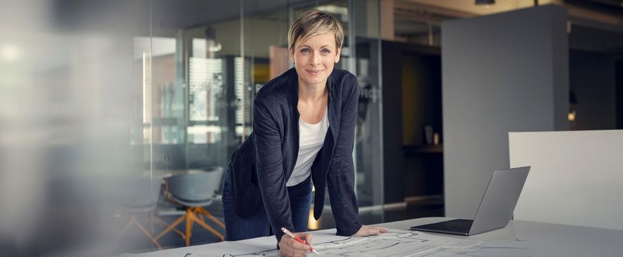 Frau im Büro an ihrem Schreibtisch