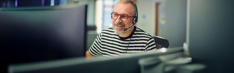 Mann mit Brille und Headset im Büro
