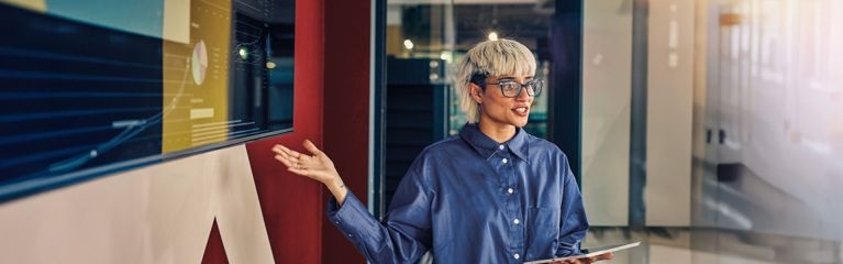 Frau mit Tablet hält eine Präsentation