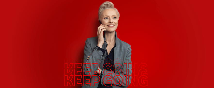 Geschäftsfrau telefoniert mit Handy vor rotem Hintergrund