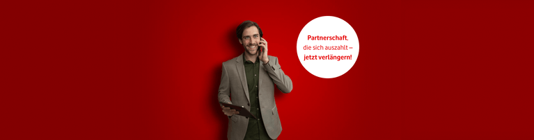 Person im Anzug telefoniert vor rotem Hintergrund mit weißem Button "Partnerschaft die sich auszahlt - jetzt verlängern!"