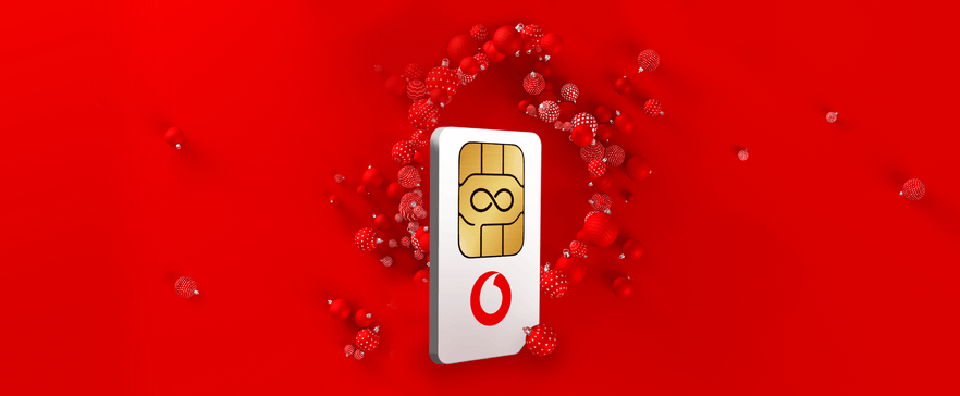 Vodafone SIM-Karte mit Unendlichkeitssymbol auf rotem Hintergrund, umgeben von festlichen roten Kugeln.