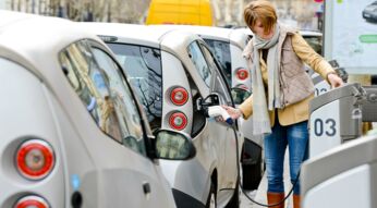 Woman charging Electric Car on Paris Street