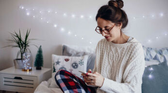 Junge Frau informiert sich am Smartphone über iPhone-7-Tricks.