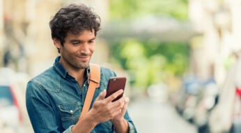 Mann liest Facebook-Nachrichten auf seinem Smartphone