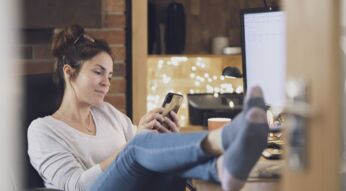 Frau schaut sich Fotos am iPhone an.