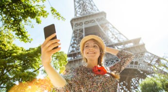 Eine Frau macht ein Selfie am Eiffelturm in Paris