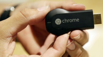 Den Google Chromecast in der Hand halten.