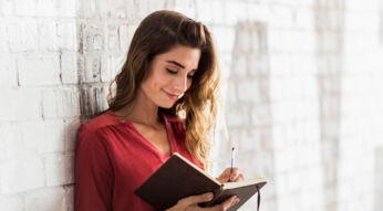 Eine Frau notiert etwas in einem Notizbuch