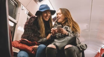 Freundinnen lachen über ein GIF im Smartphone.