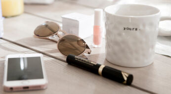 Ein iPhone und eine Kaffeetasse in einer Bürosituation