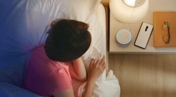 Frau stellt den Wecker ihres Amazon Echo Dots.