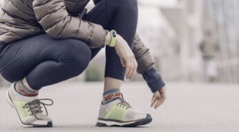Frau nutzt Fitness-Tracker beim Laufen