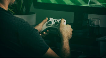 Mann spielt Xbox-Games mit Controller.