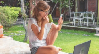 Junge Frau steuert ihren Rasenmäher via App