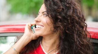 Junge brünette Frau telefoniert mit ihrem Smartphone