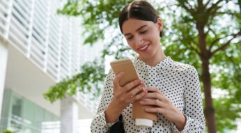 Frau lädt Dateien über ihr Smartphone in die Cloud hoch.