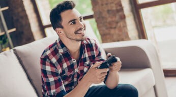 Junger Mann zockt Spider-Man über die Konsole.