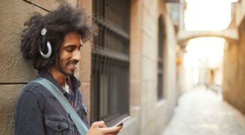Junger Mann hört Musik mit Spotify auf dem Samsung-Smartphone.