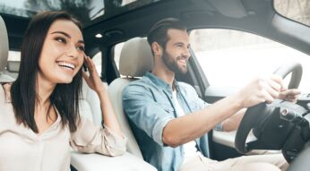 Ein junges Pärchen fährt mit dem Auto und navigiert über Google Maps