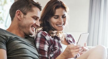 Junges Paar testet die neuen Gmail-Benachrichtigungen am Smartphone.