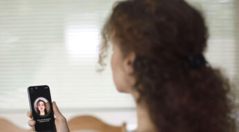 Frau scannt Gesicht mit Face ID am iPhone.