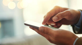 Junger Mann nutzt iOS 12 am iPhone.