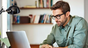 Junger Mann nutzt Gmail am Laptop.