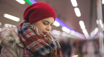 JUnge Frau schaut auf ihr Smartphone.