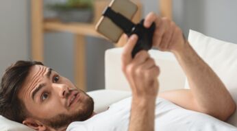 Junger Mann spielt Creative Destruction auf seinem Smartphone