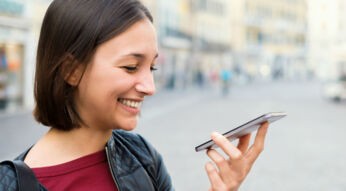 Junge Frau nutzt Bixby am Smartphone auf Deutsch.