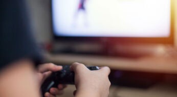 Junger Mann zockt Apex Legends mit Controller.