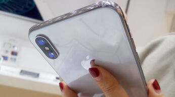 Frau hält iPhone X in ihrer Hand.