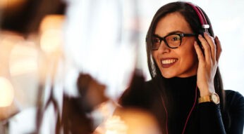 Junge Frau hört am Mac via iTunes Musik.