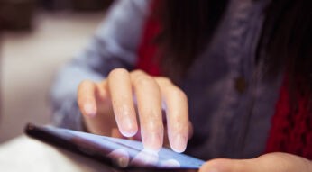 Frau lädt am Smartphone eine Webseite als PDF herunter.