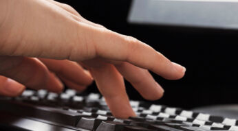 Menschliche Hand drückt Tasten auf der Tastatur.