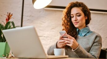 Frau nutzt Google Fotos auf Smartphone und Notebook