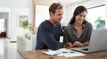 Eine Frau erklärt ihrem Mann, wie er Dateien mit Dropbox Transfer versendet.