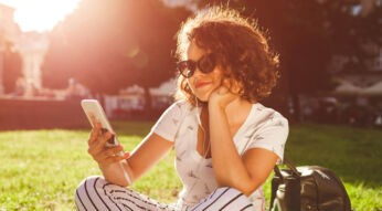 Junge Frau ändert die Deezer-Sprache am Smartphone.