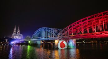 Brücke wird in den Farben von Vodafone und Unitymedia angeleuchtet in "The perfect match"