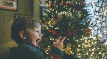 Junge vor Weihnachtsbaum