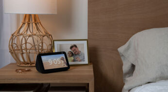 Der Amazon Echo Show 5 steht auf einem Nachttisch neben dem Bett.