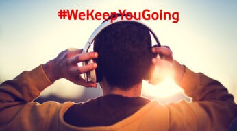 Man von hinten mit Kapuzenpulli und Kopfhörern hört Wissens-Podcasts