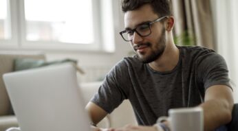 Mann sitzt am Laptop