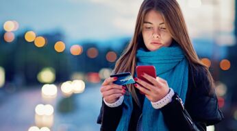 Frau richtet Google Pay mit Smartphone und Kreditkarte ein.