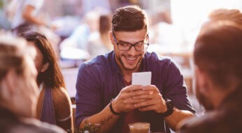 Mann sendet Geld per PayPal mit dem Smartphone